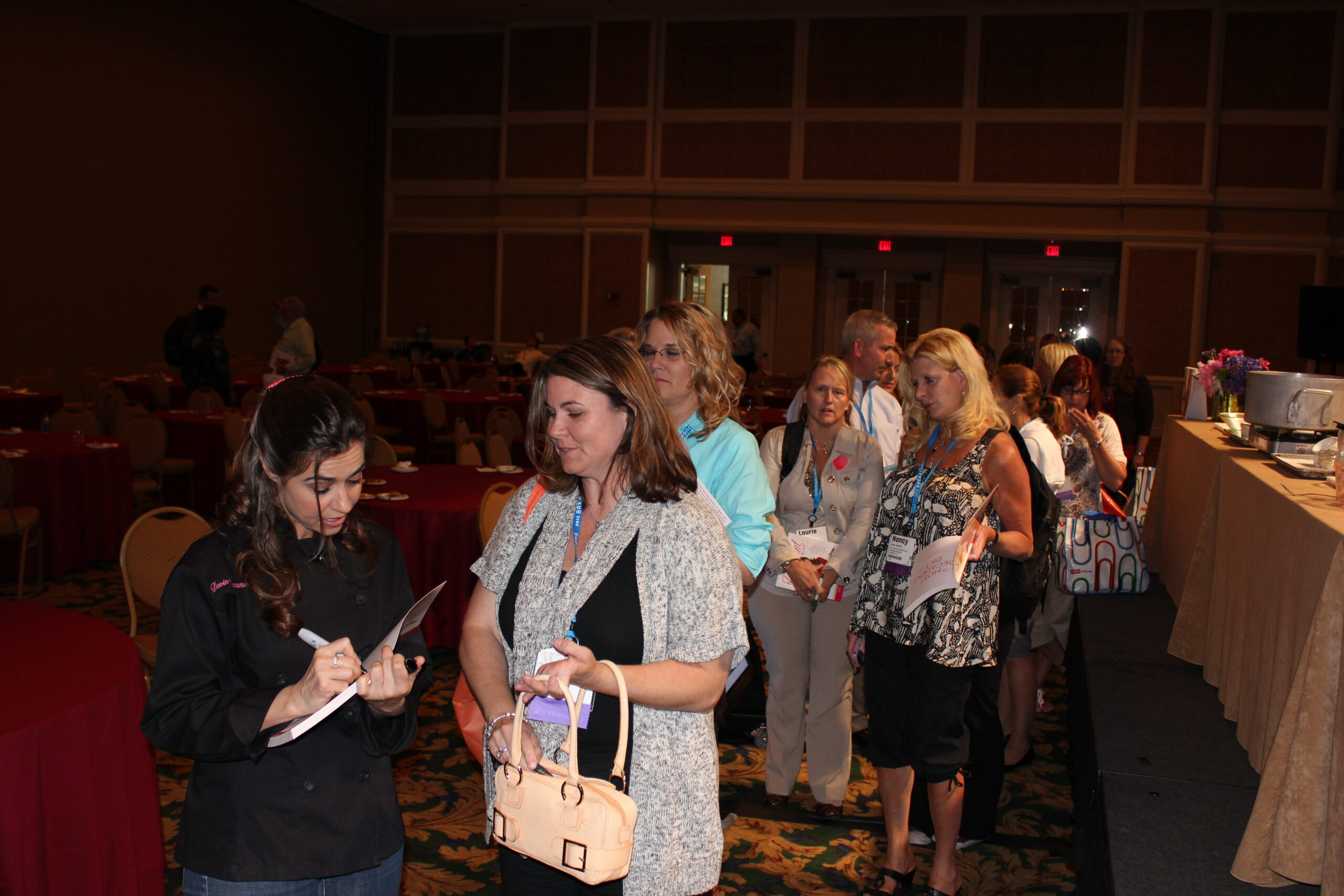 A line of attendees waiting for Devin Alexander to sign books after her talk