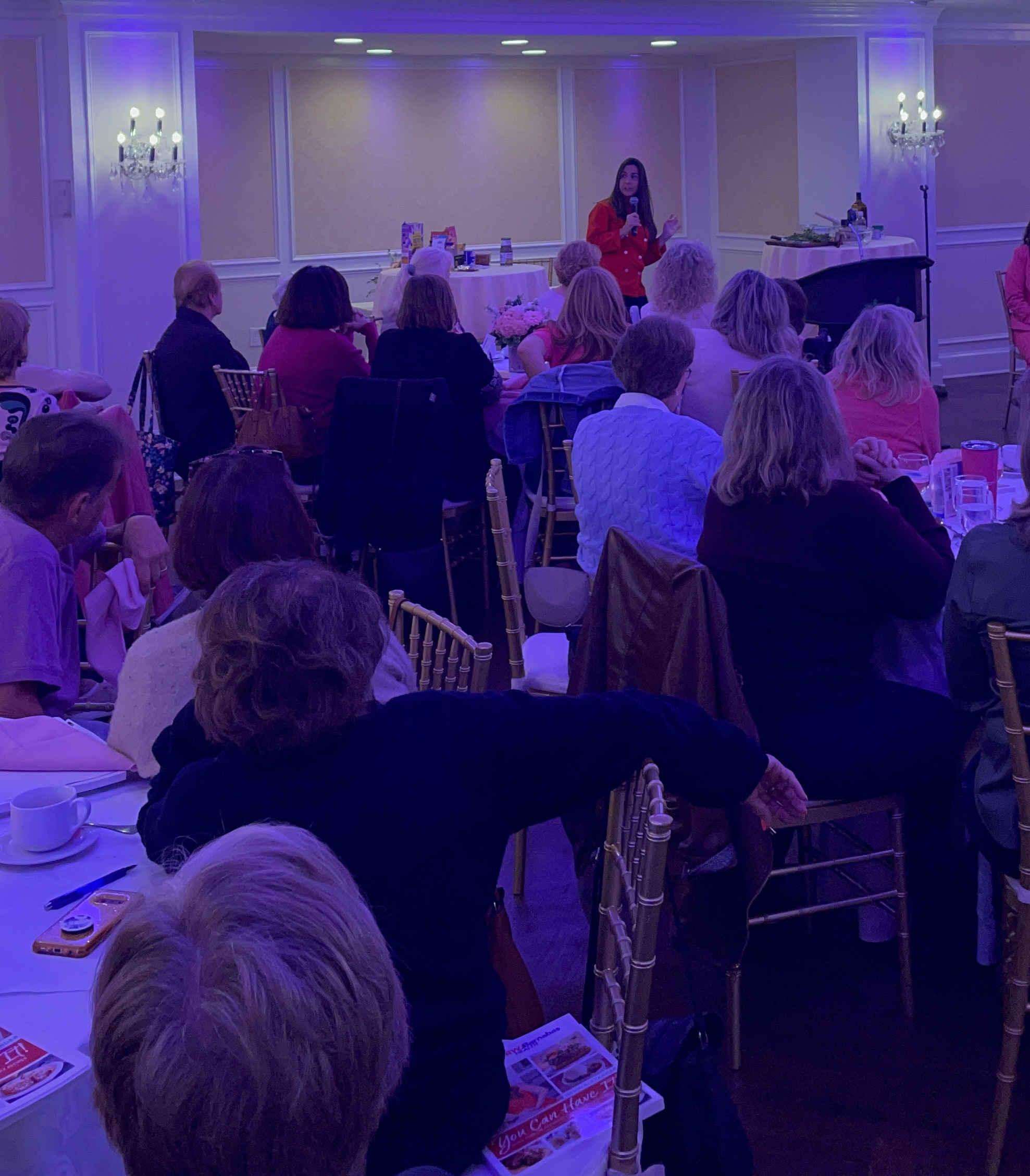 Devin Alexander speaking to a packed room at a keynote event